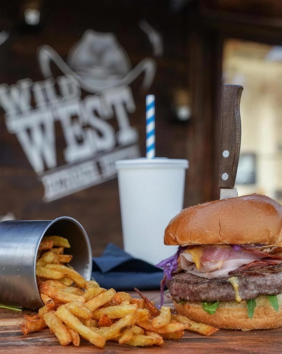 Burger and fries in a metal cup in front of the Wild West wall sign