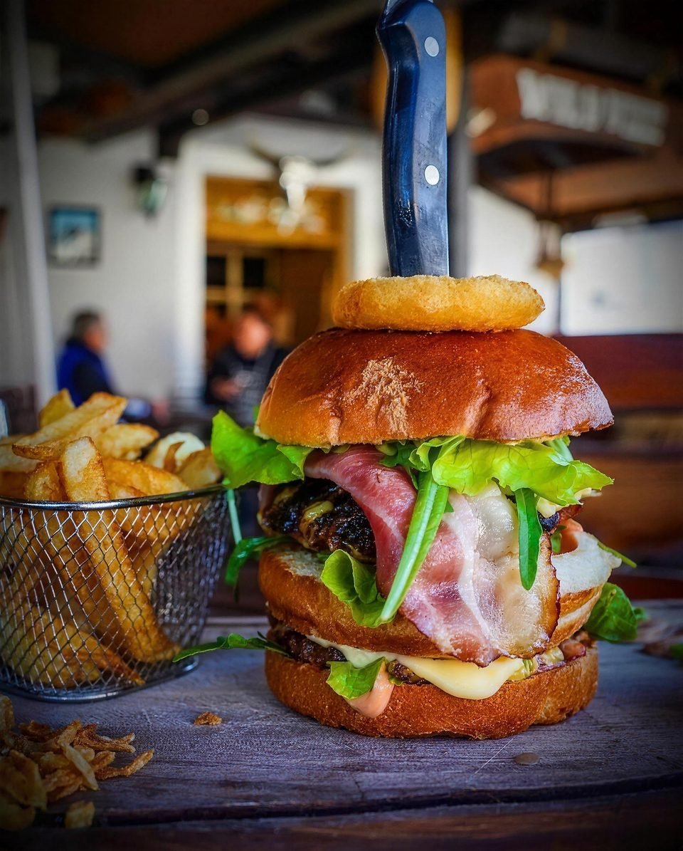Burger with an onion ring on the restaurant terrace