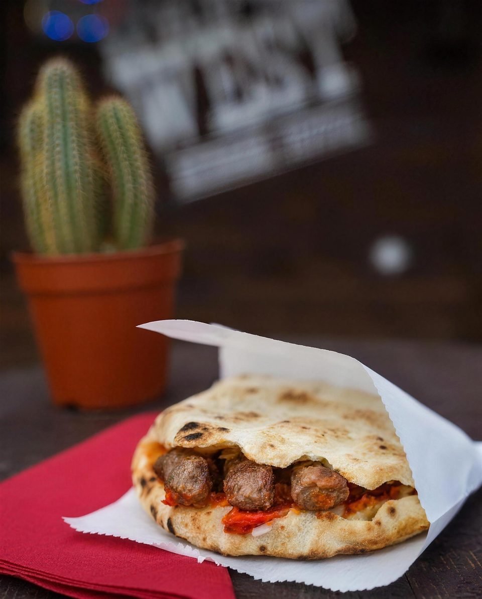 Ćevapi in flatbread beside a cactus and the Wild West sign