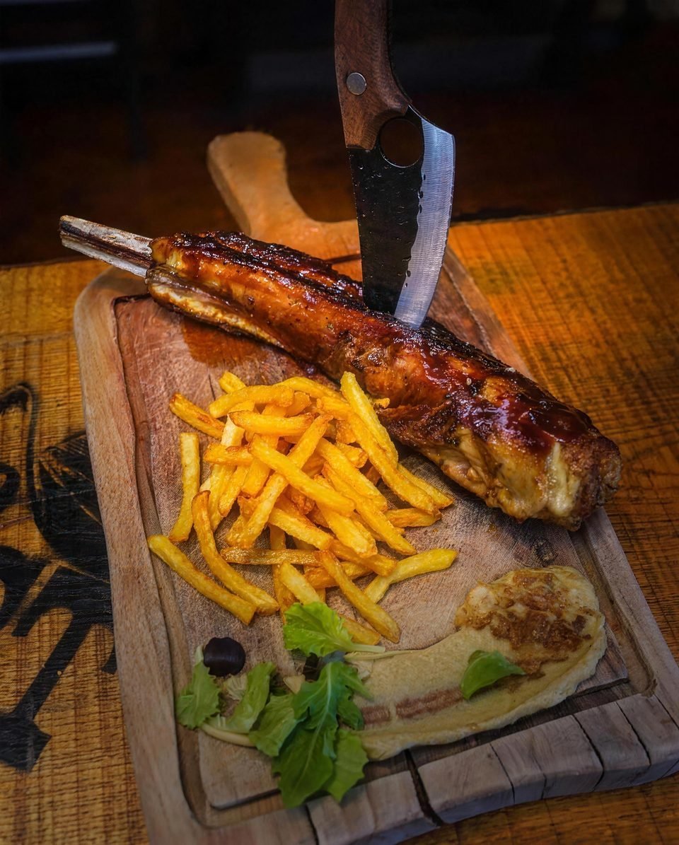 Marinated pork ribs with fries on a wooden board